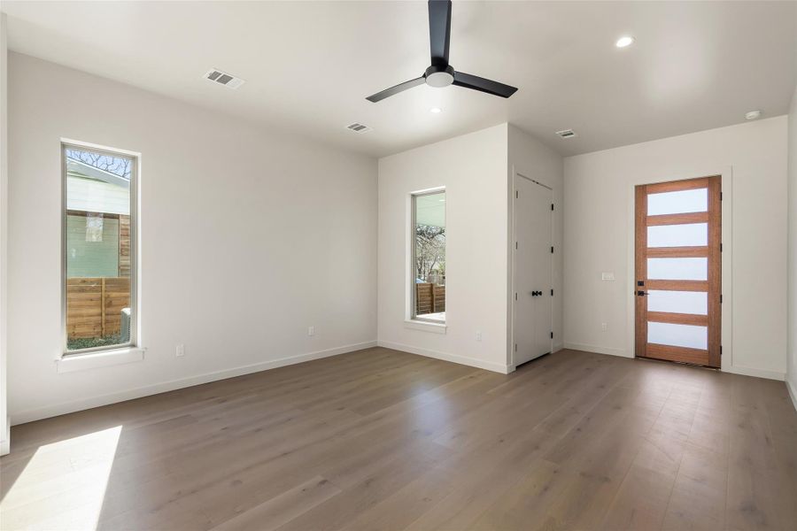 Empty room featuring light wood-type flooring, visible vents, and baseboards