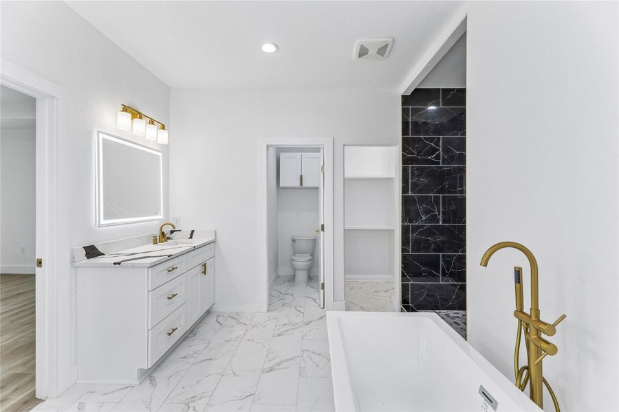 Luxurious soaking tub and sleek vanity with modern fixtures elevate this contemporary bathroom design.