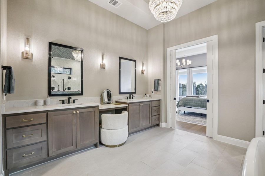 Dual vanities and modern fixtures complete the spa-like experience in the owner's suite.