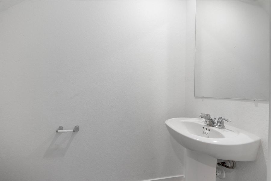 Powder room conveniently located near entryway ,perfect for guests.