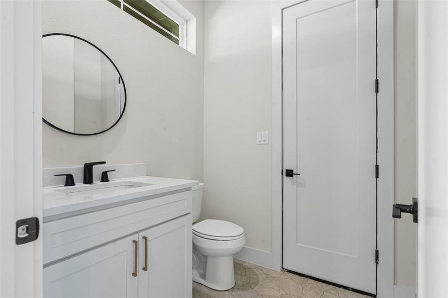 Half bath with vanity and light tile patterned floors Half bath with vanity and light tile patterned floors