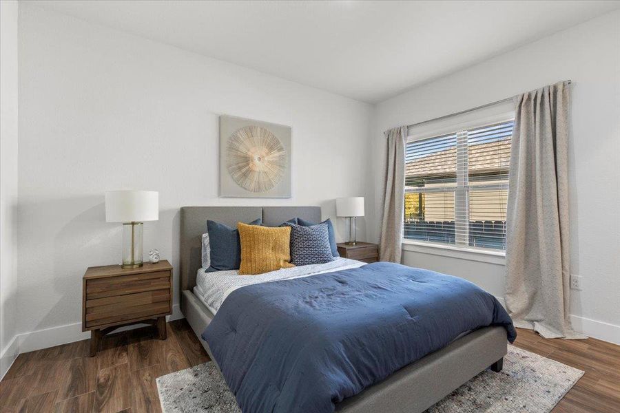 Bedroom with baseboards and dark wood-type flooring