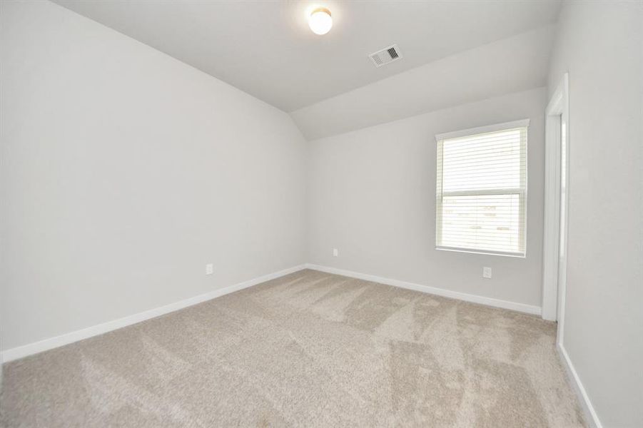 Secondary bedroom features plush carpeting, large windows that let in plenty of natural light, bright paint, and spacious closets.