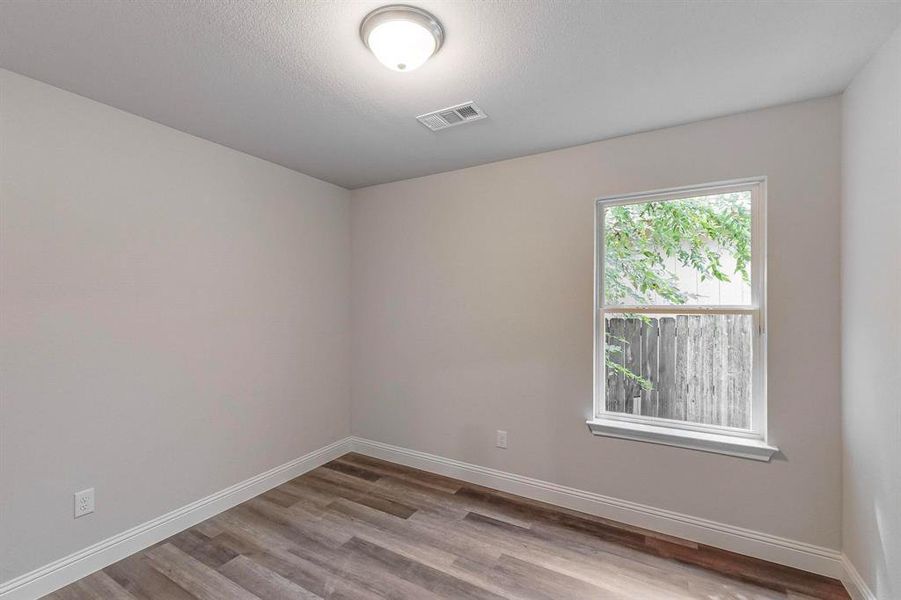 Spare room featuring light wood-type flooring and a textured ceiling