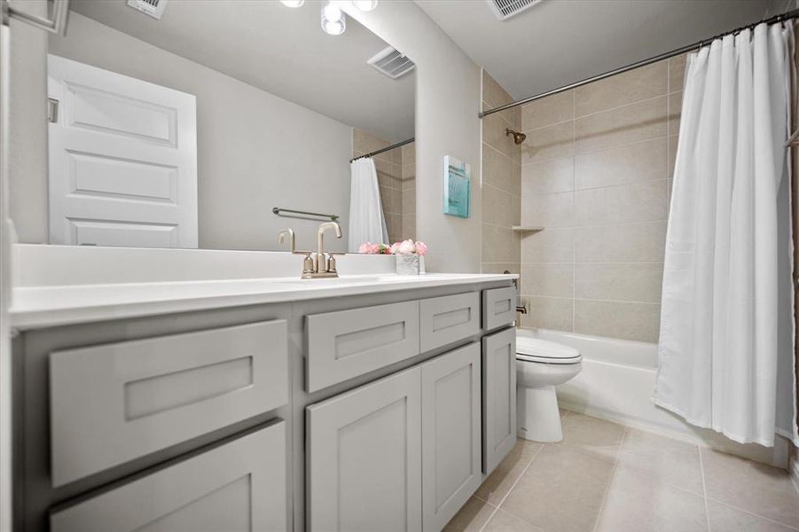 Full bathroom featuring vanity, tile patterned flooring, and shower / bath combination with curtain Full bathroom featuring vanity, tile patterned flooring, and shower / bath combination with curtain