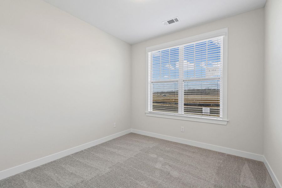 Spare room featuring light colored carpet and baseboards Spare room featuring light colored carpet and baseboards