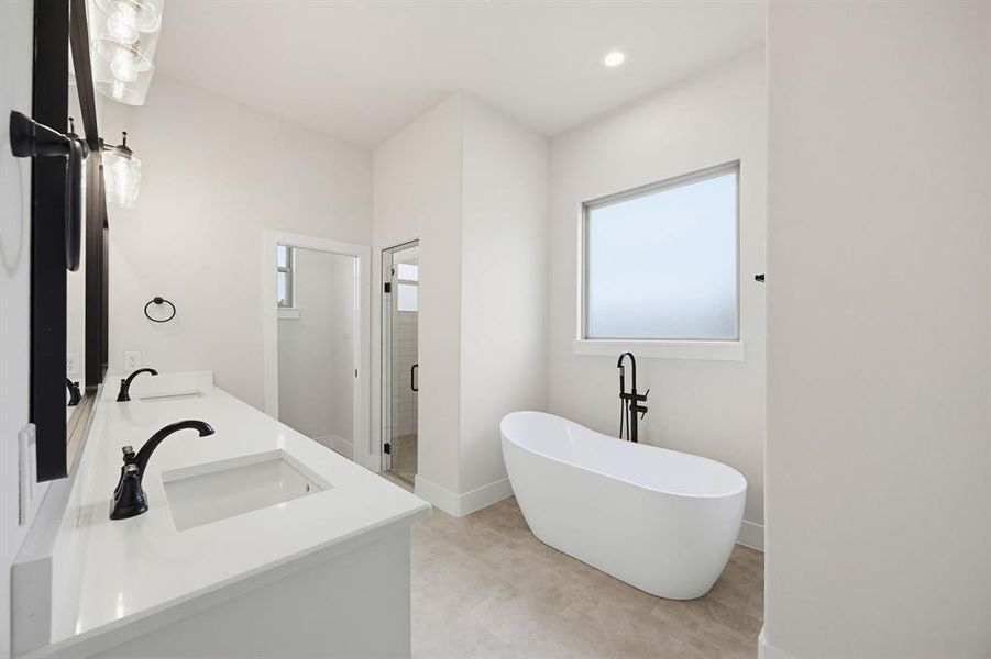 Sleek freestanding soaking tub with a floor-mounted matte black faucet