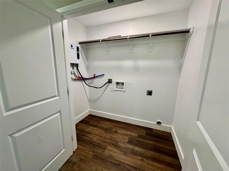Washroom featuring dark wood finished floors, washer hookup, electric dryer hookup, and tankless water heater