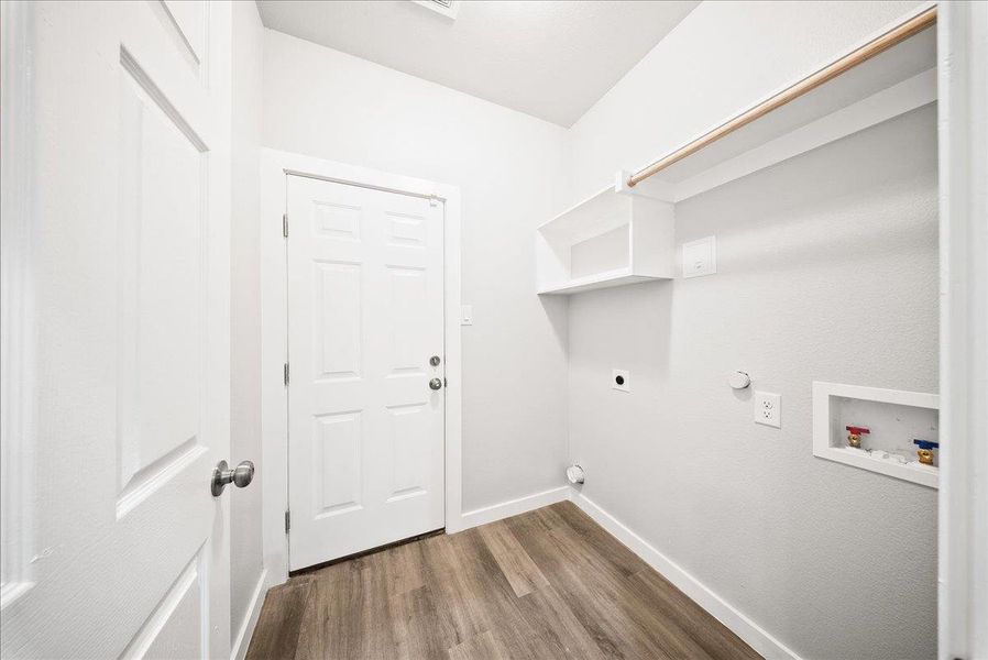 Laundry area with dark wood-style flooring, gas dryer hookup, electric dryer hookup, and hookup for a washing machine Laundry area with dark wood-style flooring, gas dryer hookup, electric dryer hookup, and hookup for a washing machine
