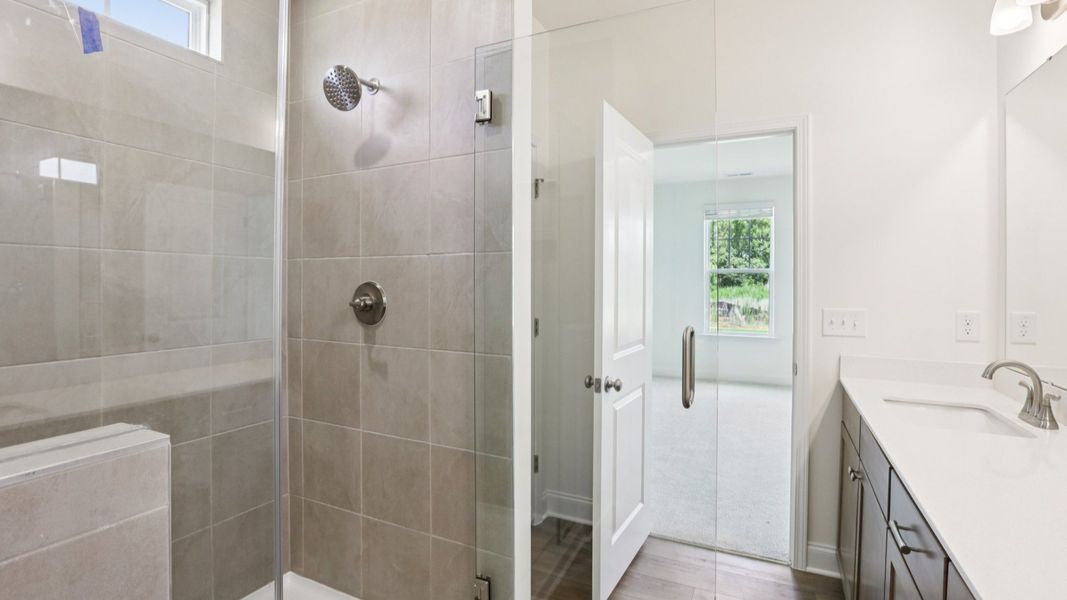 Pendleton home plan primary bathroom with tile shower, dual vanities and linen closet Pendleton home plan primary bathroom with tile shower, dual vanities and linen closet