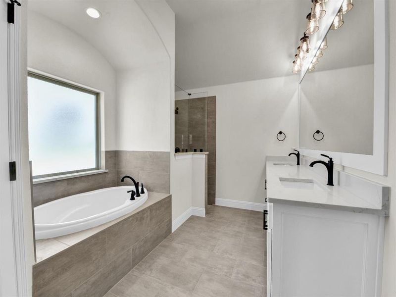 Full bath with a bath, double vanity, a sink, and a walk in shower Full bath with a bath, double vanity, a sink, and a walk in shower