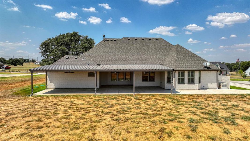 Rear view of house featuring a massive extended, covered patio