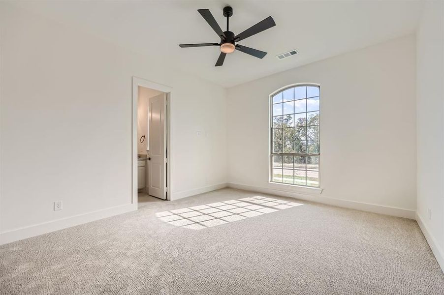 Carpeted empty room featuring ceiling fan