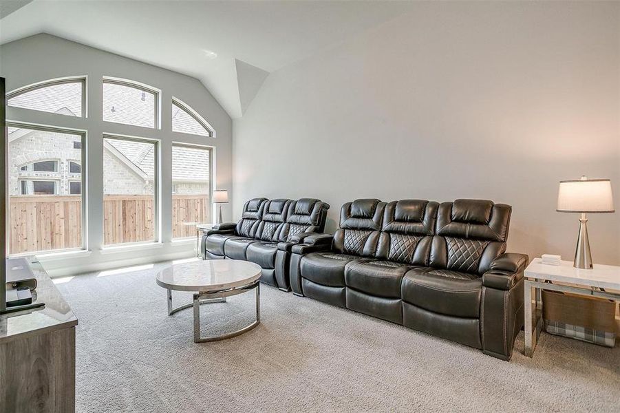 Living area featuring carpet and vaulted ceiling Living area featuring carpet and vaulted ceiling