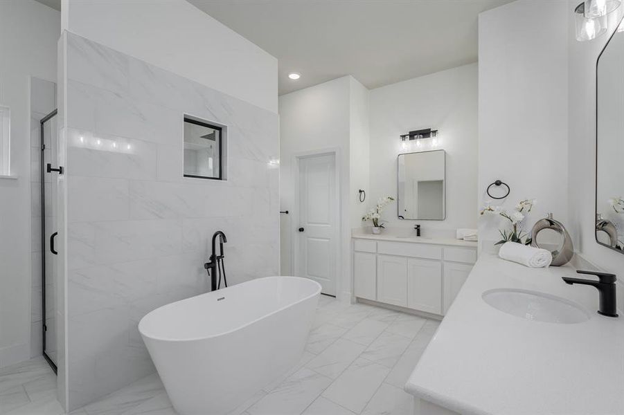 Bathroom with shower with separate bathtub, vanity, and tile walls