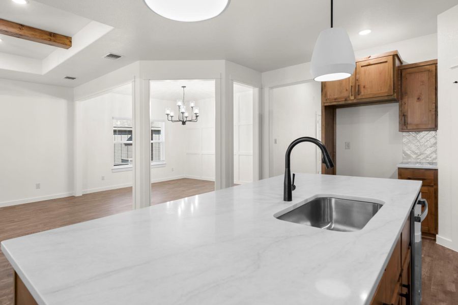 A well-appointed kitchen island with a sleek sink anchors this airy open-concept living space.
