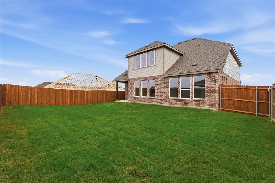 Expansive grassy backyard featuring a full privacy fence