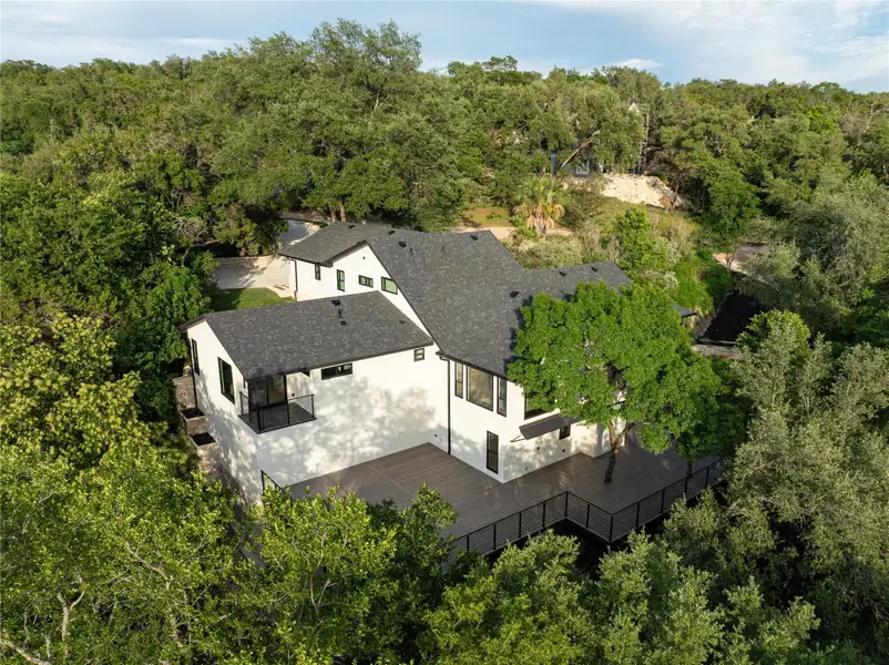 Aerial view of property and surrounding area featuring a heavily wooded area. Private yard that backs to a creek
