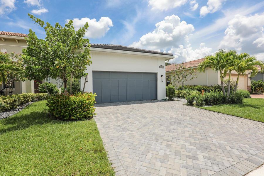 Front exterior of a new home in PGA Village Verano, Port St. Lucie, FL, highlighting curb appeal (Image 22).