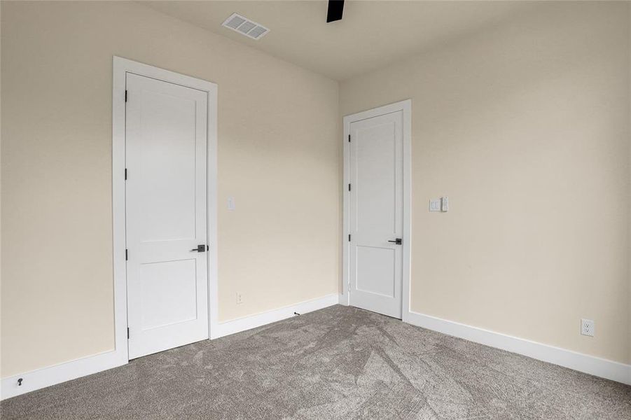 Unfurnished bedroom with carpet flooring and baseboards Unfurnished bedroom with carpet flooring and baseboards