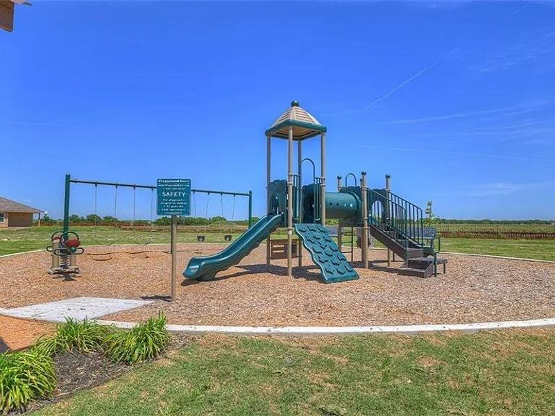 Playground area featuring a multi-level play structure with slides and climbing elements, a swingset, and a spring rider Playground area featuring a multi-level play structure with slides and climbing elements, a swingset, and a spring rider