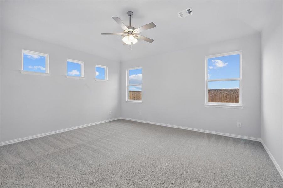 Spare room featuring light colored carpet and a ceiling fan
