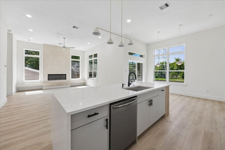 A waterfall island anchors the space while the built in beverage center, floating shelves, and ceiling height cabinetry maximize both storage and style. Dedicated beverage station features floating oak shelving, custom cabinetry, and integrated wine storage for effortless entertaining.