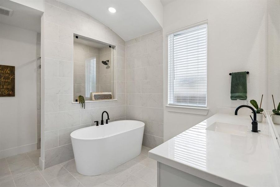 Contemporary bathroom featuring a freestanding soaking tub, a tiled shower with a glass panel, and a double vanity with white countertops Contemporary bathroom featuring a freestanding soaking tub, a tiled shower with a glass panel, and a double vanity with white countertops