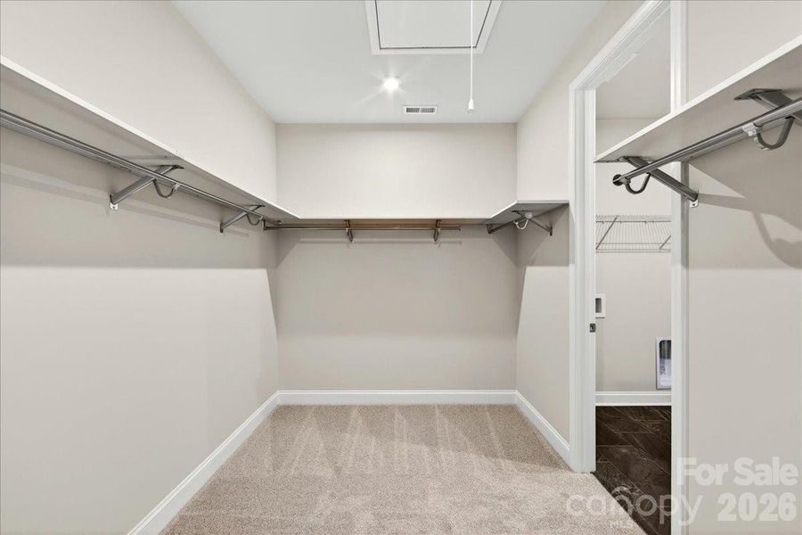 Primary Walk-in closet with upgraded shelving and access to the laundry room Primary Walk-in closet with upgraded shelving and access to the laundry room