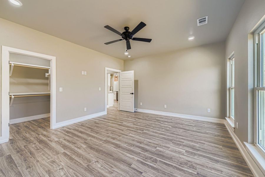 Unfurnished bedroom with recessed lighting, a walk in closet, light wood-type flooring, and ceiling fan
