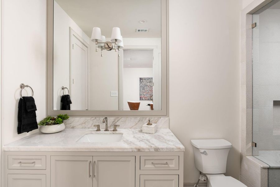 Each secondary, en-suite bathroom features custom-built cabinetry, marble counters, Brizo Litze polished nickel fixtures, and a unique tile design. Each secondary, en-suite bathroom features custom-built cabinetry, marble counters, Brizo Litze polished nickel fixtures, and a unique tile design.