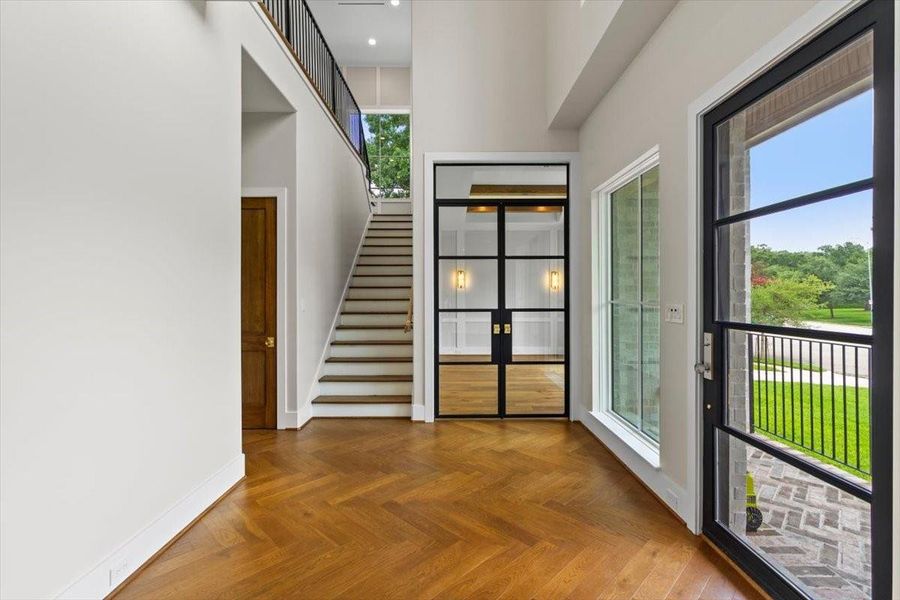 Dramatic two story entry with oversized steel entry door. Double steel doors to office - and art nook. Custom herringbone floor design