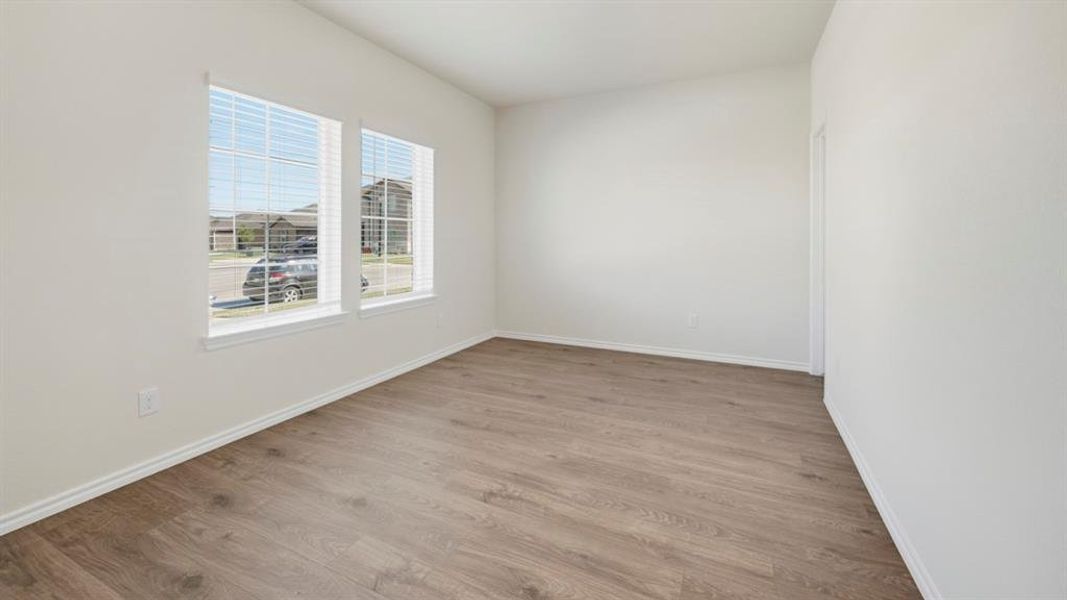 Unfurnished room featuring light wood finished floors and baseboards