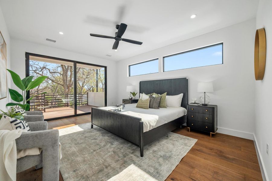 Bedroom with wood finished floors, visible vents, baseboards, recessed lighting, and access to exterior