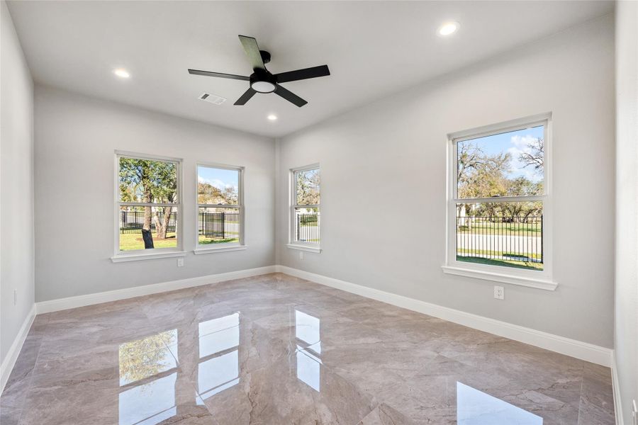 Spare room with light marble finish flooring, healthy amount of natural light, recessed lighting, and ceiling fan