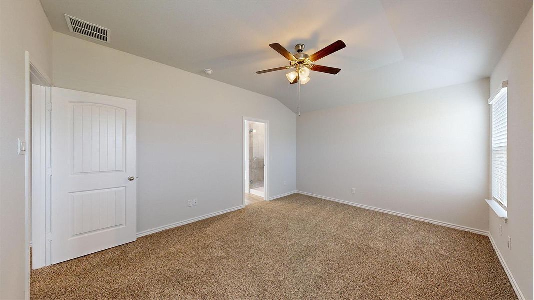 Spacious room featuring vaulted ceilings, neutral-toned carpeting, and a ceiling fan with integrated lighting Spacious room featuring vaulted ceilings, neutral-toned carpeting, and a ceiling fan with integrated lighting