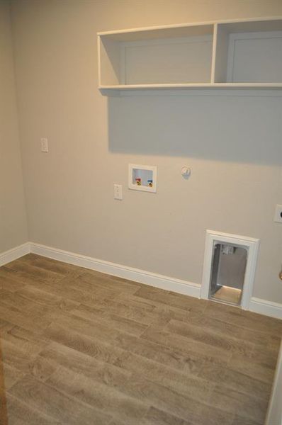 Laundry area with gas dryer hookup, washer hookup, hardwood / wood-style flooring, and hookup for an electric dryer