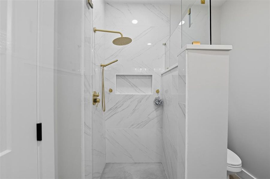Bathroom with a marble finish shower and toilet Bathroom with a marble finish shower and toilet
