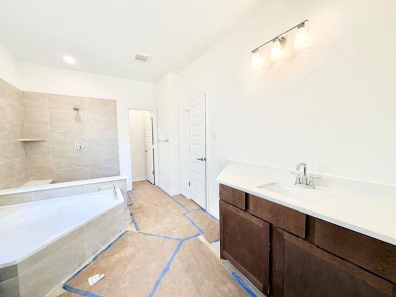 Bathroom with vanity, a tile shower, and tiled tub