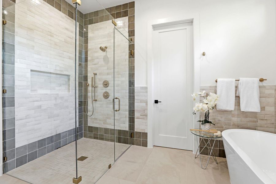 Bathroom with tile walls, a soaking tub, a stall shower, a wainscoted wall, and tile patterned flooring Bathroom with tile walls, a soaking tub, a stall shower, a wainscoted wall, and tile patterned flooring