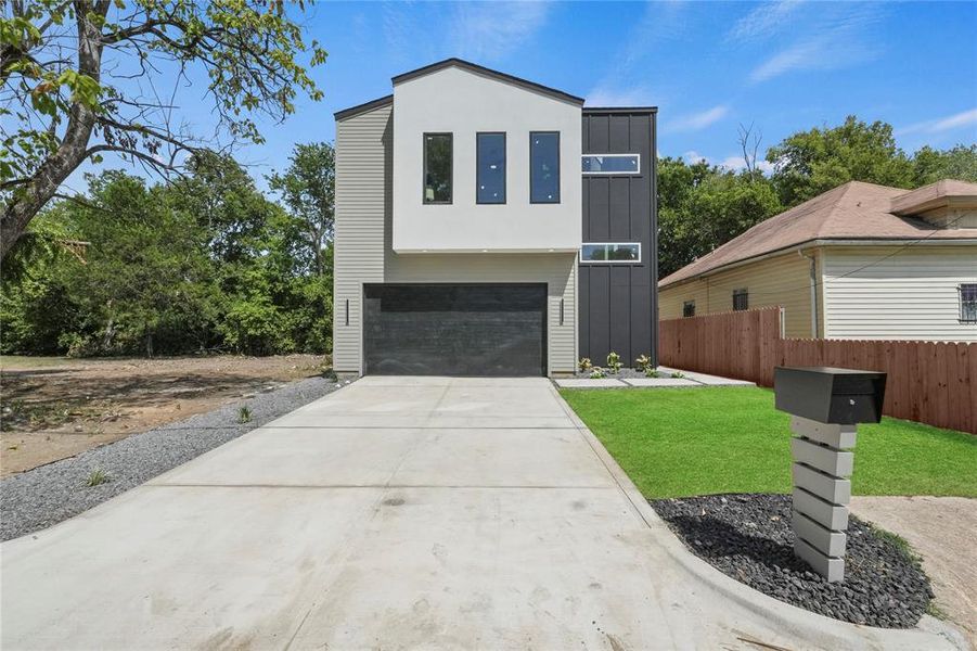 Contemporary Modern home with a front yard and a garage