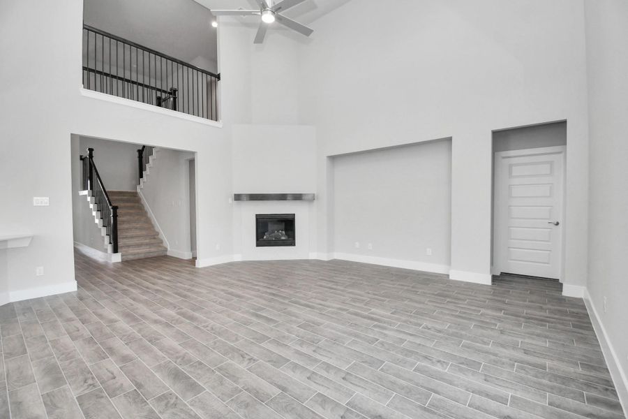 Gather the family and guests together in your lovely living room! Featuring soaring high ceilings, recessed lighting, ceiling fan, custom paint, gorgeous floors, and large windows that provide plenty of natural lighting throughout the day.