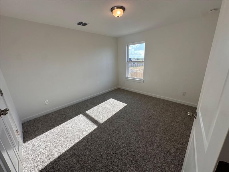 Unfurnished room featuring dark colored carpet Unfurnished room featuring dark colored carpet