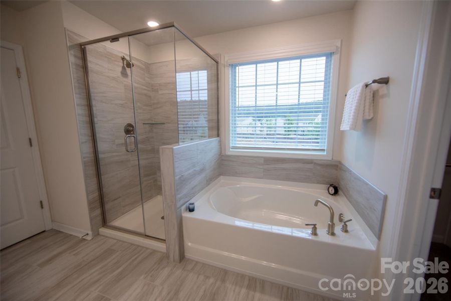 Primary bathroom featuring a garden tub and separate shower.