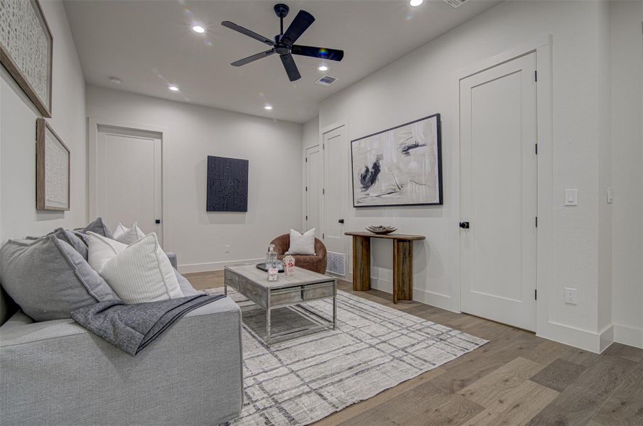 Living area with wood finished floors, recessed lighting, ceiling fan, and baseboards Living area with wood finished floors, recessed lighting, ceiling fan, and baseboards