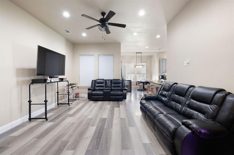 Living room with light wood-type flooring and ceiling fan