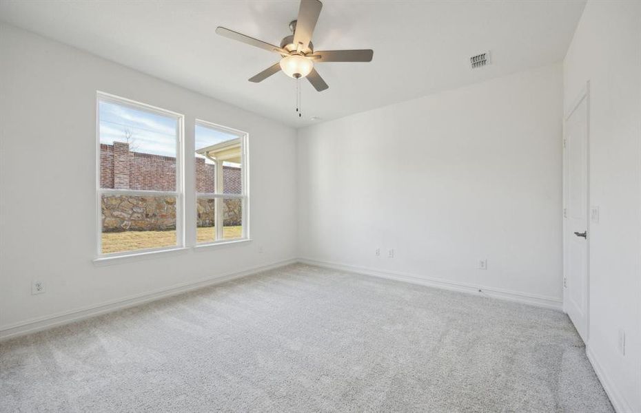 Spacious owner's suite with large windows *real home pictured