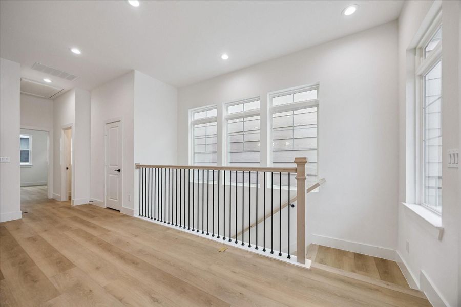 Open second-floor gathering space with polished flooring and soft natural light
