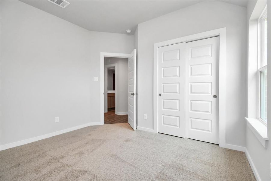 Generously sized secondary bedrooms featuring spacious closets, soft and inviting carpeting underfoot, large windows allowing plenty of natural light, and the added touch of privacy blinds for your personal retreat.