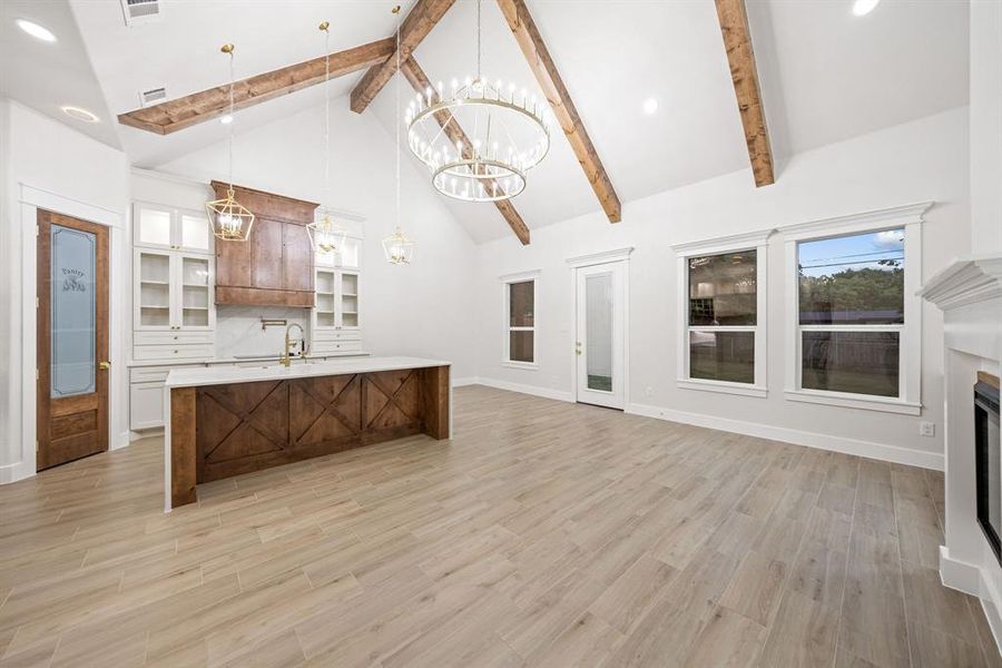 Vaulted ceiling with exposed wood beams, bright white walls, and wood-finish flooring Vaulted ceiling with exposed wood beams, bright white walls, and wood-finish flooring